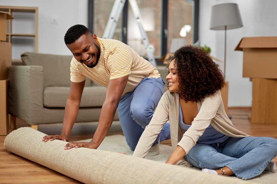 homeowners rolling out carpet in their new home